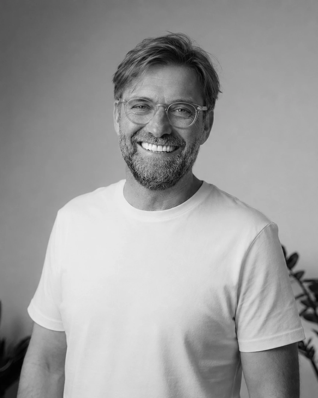 Lächelnder Mann in weißem T-Shirt, repräsentiert die Agentur Bonn mit freundlicher Ausstrahlung.